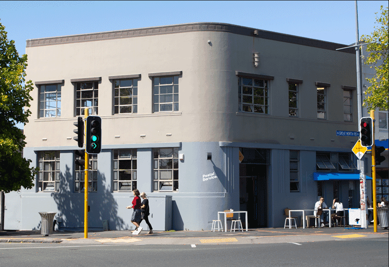 Outside of Postal Service cafe: a grey building in art deco style on a corner site