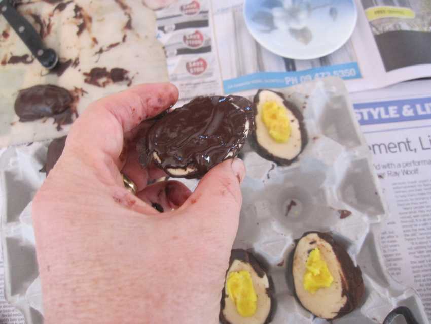 hand holding joined egg being painted around edges