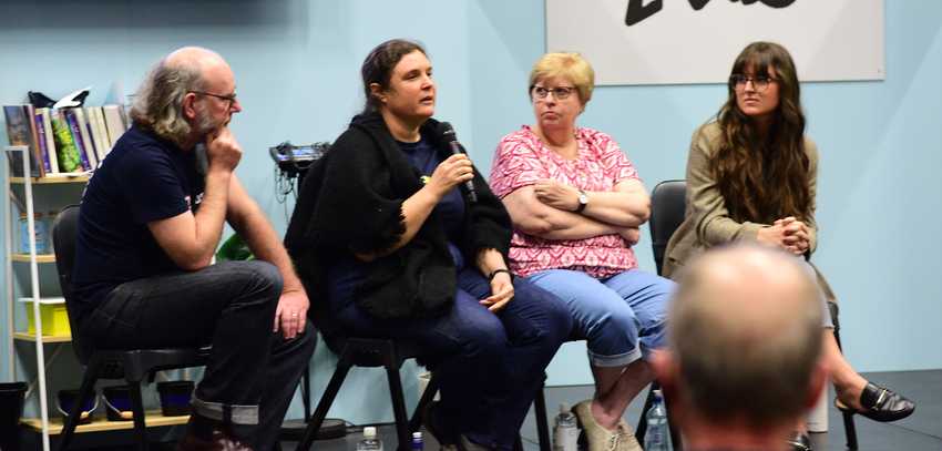 four people seated in a row on a stage