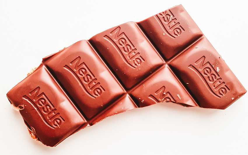 a broken off section of a chocolate block with Nestle stamped onto each piece