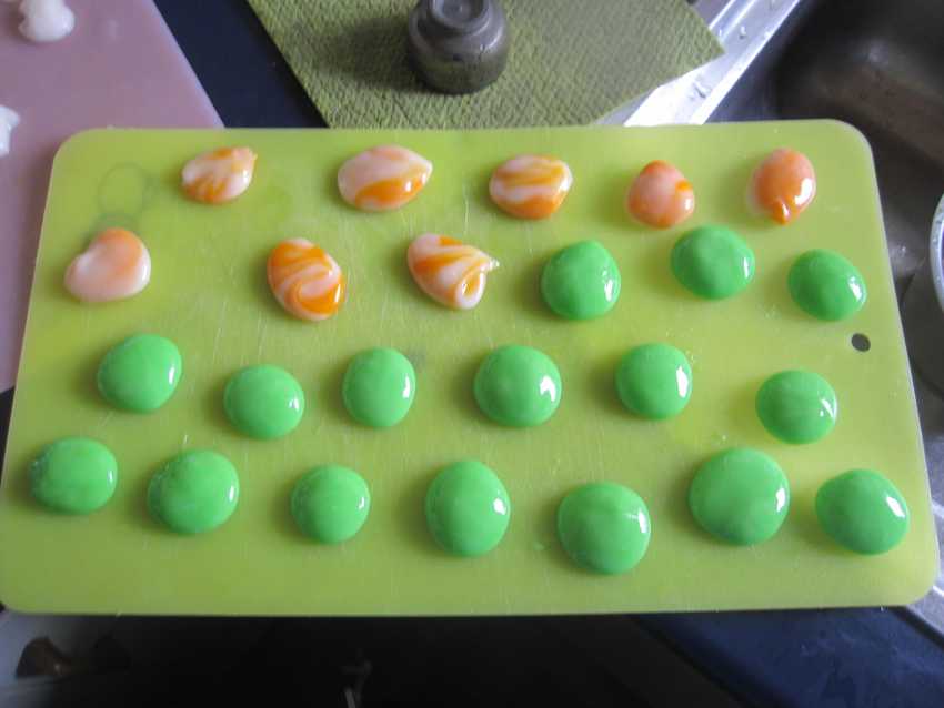 tray with two rows white balls with orange streaks showing through and several rows of lurid green balls