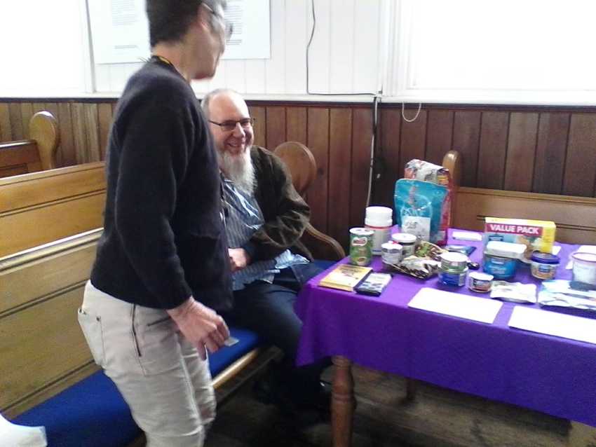 Martin and a member of the congregation chatting at the Just Kai table.